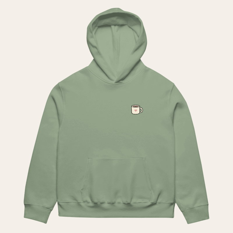 Sage Nothing Urgent hoodie laid flat, front view with small heart mug chest print
