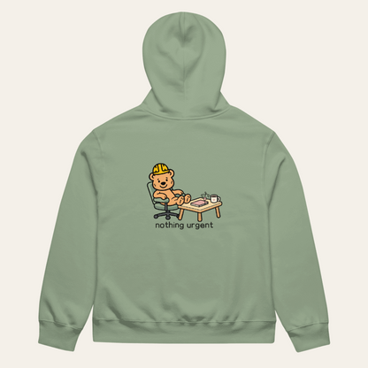 Sage Nothing Urgent hoodie laid flat, back view with Tee Bear desk and plant artwork