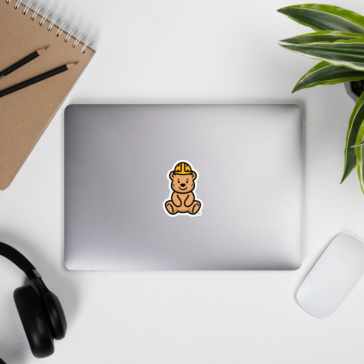 Tee Bear Sticker by By Tee, on a laptop beside headphones and a plant