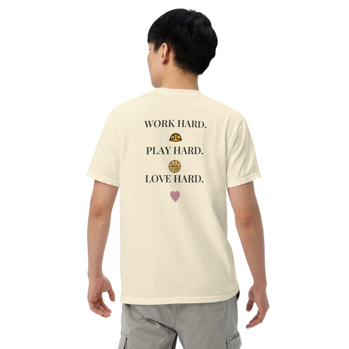 Model wearing the Ivory Work Hard Icons relaxed-fit T-shirt, showing the back slogan and helmet, basketball with a bear-head emblem, and heart.
